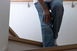 階段で膝を押さえているシニア女性（日本人、60代、顔無し）