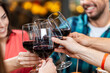 © Syda Productions - leisure, people and celebration concept - close up of happy friends drinking red wine and toasting at restaurant or pub