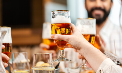 Wall Mural - leisure, people and celebration concept - close up of happy friends having dinner and drinking beer at restaurant or pub