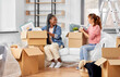 © Syda Productions - moving, people and real estate concept - women unpacking boxes at new home