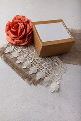 Wall Mural - Brown paper present box, fabric rose flower, blank postcard, sackcloth and lace on white background. Valentines day, birthday, wedding