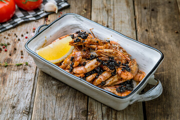 Wall Mural - boiled shrimp on plate with lemon and black caviar