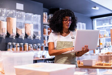 Black Female Vendor Inventorying Goods