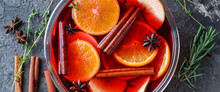 Tasty Mulled Wine With Orange And Apple Slices In Bowl On Grey Background, Closeup