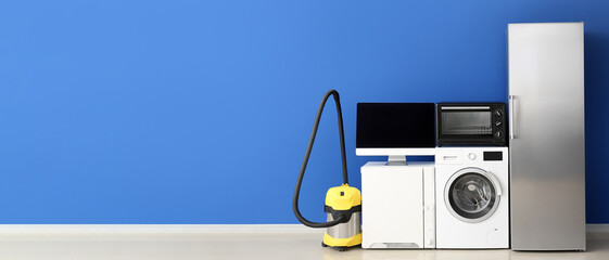 Different household appliances on blue background with space for text