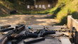 Numerous guns, rifles, and ammunition bullets placed on a wooden table near the shooting range. Outdoor gun range competition. No people. High quality photo