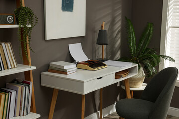 Wall Mural - Comfortable writer's workplace interior with typewriter on desk near grey wall