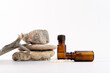 Homeopathy concept with white globules in glass bottle on white background with natural stones