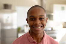 Portrait Of Happy African American Male Teenager In Kitchen
