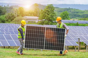 a team of two asian men install solar panels. work on installing solar panels at a solar power gener