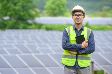 Asian male engineer Work with solar panels and install solar panels at photovoltaic power stations working on industrial solar energy storage.