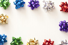 Border Of Colorful Shiny Metallic Ribbon Bows For Packaging Gifts Around A Central White Copy Space For A Festive Celebration