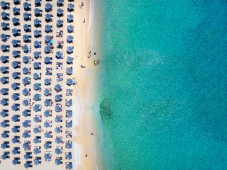 Wall Mural - aerial top down view of the symmetreical rows of sun umbrellas at the turquoise sea of elia beach, m