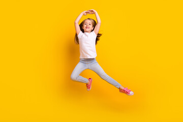 Wall Mural - Full length photo of funky sweet schoolgirl dressed white t-shirt dancing jumping high isolated yellow color background