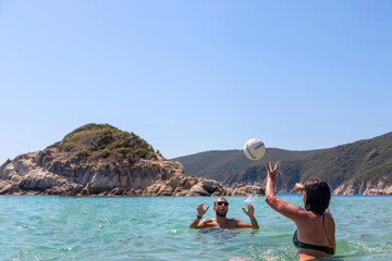 Young people group have fun and play volleyball in water at the beach.Traveling, vacation and fun