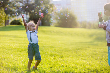 Canvas Print - Cute preschool blond child, playing in the park on sunset, summertime