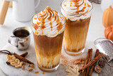 Fototapeta Kawa jest smaczna - Iced pumpkin spice latte in tall glasses topped with whipped cream