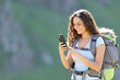 © Antonioguillem - Happy hiker consulting smartphone while trekking
