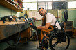 © Astarot - A man in the wheelchair does metalwork in his workshop.