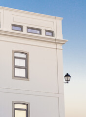 White building at sunset against a blue sky with a vintage lantern