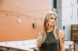 © Drew Woolery - Woman holding cocktail on rooftop