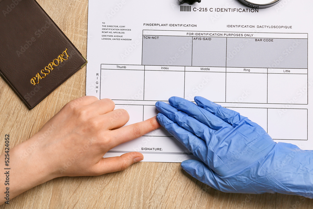 Forensic expert taking finger print of woman on table