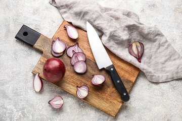 Composition with wooden board of red onion and knife on grunge background