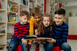 © Tina kids photo - school children in the library reading books, doing homework, prepare a school project for lessons
