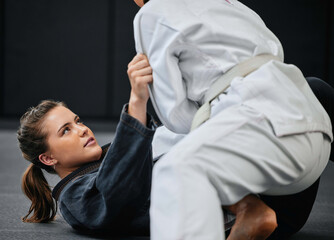 Poster - Strong, female and martial arts fighter training at an exercise studio with an opponent. Fit, young and active woman in a defense lesson at a dojo. Athlete lady practicing jujutsu with a partner.