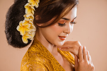 attractive balinese woman wearing kebaya over brown background