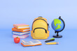 Concept of back to school, learning and onlline education banners. Yellow backpack with books stack, globe, apple and writing accessories. 3d high quality render