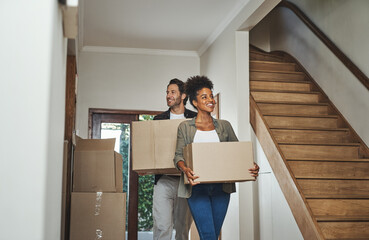 Wall Mural - Excited, happy and young couple moving into a new home together while carrying and packing household boxes. Smiling, positive and cheerful husband and wife in a lovely modern real estate property