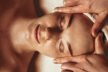Wall Mural - young attractive woman enjoying massage in spa salon. beauty treatment. natural skin care cosmetic. 