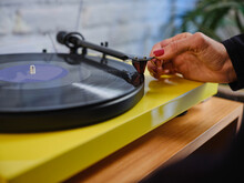 Woman Putting Vinyl Record Into Record Player