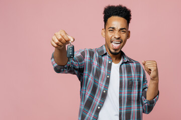 Poster - Young man of African American ethnicity 20s wear blue shirt show car key fob keyless system do winner gesture isolated on plain pastel light pink background studio portrait People lifestyle concept.