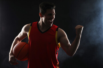 Poster - Basketball player with ball on black background