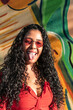 © ADDICTIVE STOCK - Smiling Latin American woman sticking tongue out against graffiti wall