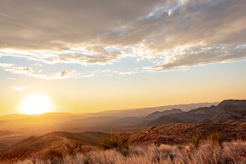 Dramatic golden sky sunset clouds over the grass fields and desert of Big Bend National Park Texas