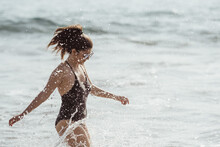 Young Woman Splashing Water At Beach