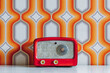 © ADDICTIVE STOCK - Red vintage radio on table against wall with white and orange geometric shapes