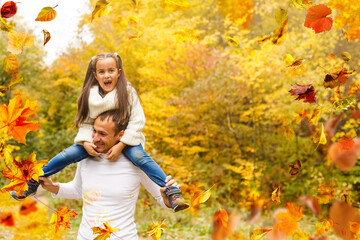 Wall Mural - Happy family father and child daughter on a walk in the autumn leaf fall in park