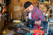 © ADDICTIVE STOCK - Mature carpenter working on drilling machine in workshop