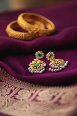 Wall Mural - Gold earring on a purple traditional indian saree