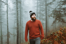 Bearded Guy In Sweater And Hat Near Fir Trees