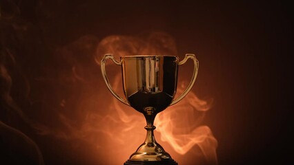Wall Mural - the golden trophy on a black background smokes around a fierce and fiery concept of competition or v
