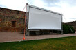 aluminum stage construction. large format white screen, tarpaulin, outdoor cinema in the park. secured with drawstrings. an evening screening under the sky is set up in the park