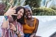 © ADDICTIVE STOCK - Positive couple of multiethnic lesbian women making faces at camera