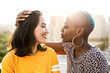 © ADDICTIVE STOCK - Multi ethnic lesbian couple hugging outdoors