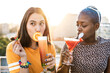 © ADDICTIVE STOCK - Multiethnic couple of cool lesbian women drinking cocktails