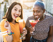 © ADDICTIVE STOCK - Multiethnic couple of cool lesbian women drinking cocktails